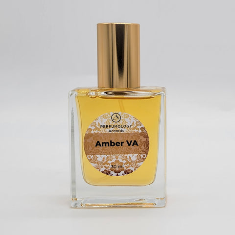 A square glass bottle with a gold cap, labeled "Amber VA" and "Perfumology Accords 30 mL." The label, designed by Vincent Avery, includes decorative designs. Inside, the bottle holds a yellowish liquid.