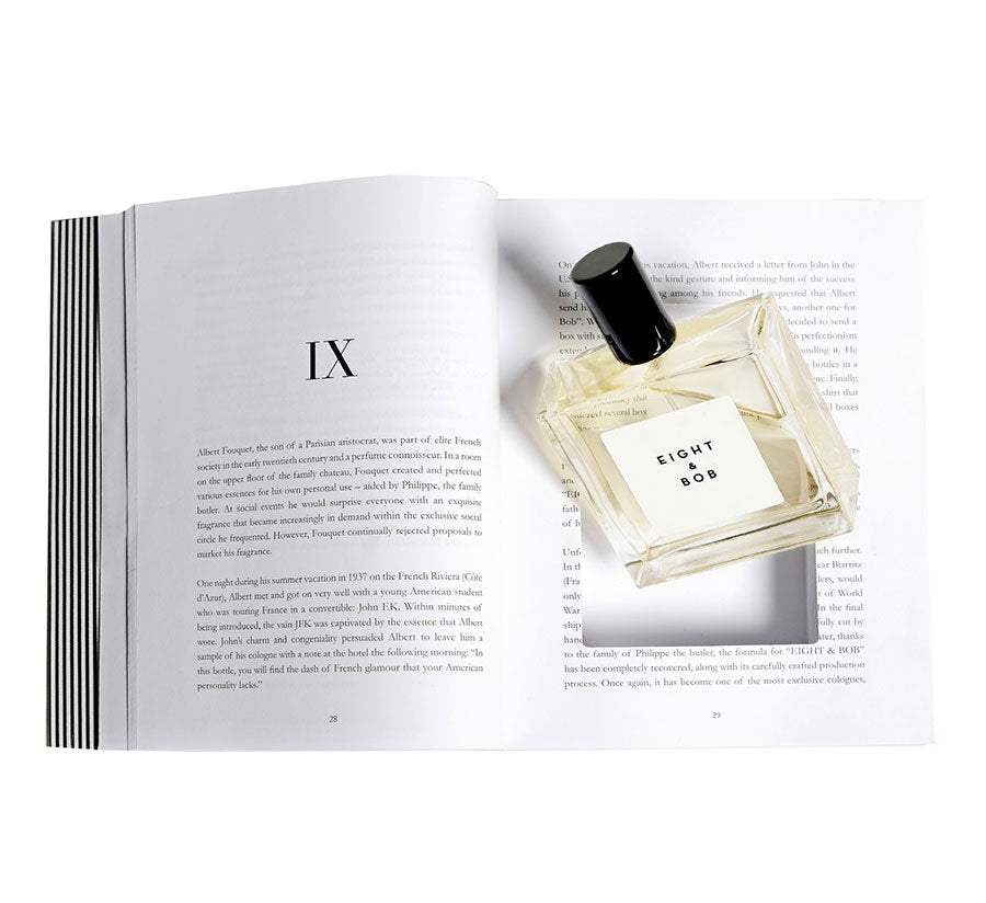 A bottle of Eight & Bob by Eight & Bob rests on an open book, partially covering the text on the left-hand page.