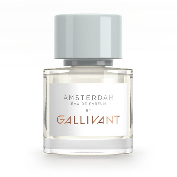 A clear glass bottle of Amsterdam by Gallivant from Gallivant Perfumes with a white label and gray cap, featuring the enchanting notes of a woody ambery fragrance.