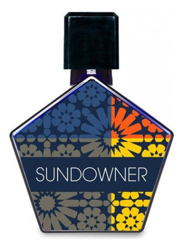 A Tauer Perfumes bottle of perfume labeled "Sundowner," featuring a pentagonal shape adorned with a colorful floral pattern, and topped with a sleek black cap exudes a hint of cocoa.