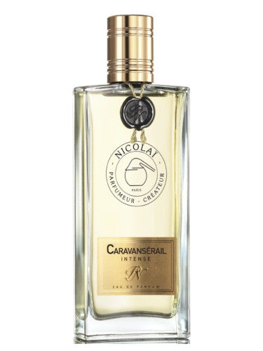 A rectangular glass bottle of Caravansérail Intense by Nicolaï with a gold cap and label showcases the new fragrance, an exquisite Amber Vanilla blend.