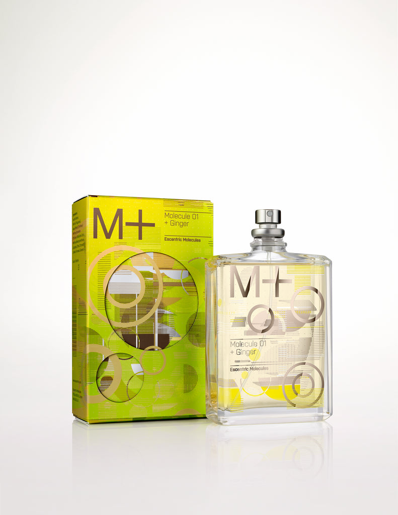 A rectangular glass perfume bottle labeled "Escentric Molecules Molecule 01 + Ginger" with a metallic cap, positioned beside its yellow and black packaging box. The unique blend of Iso E Super and ginger oil makes this fragrance truly captivating.