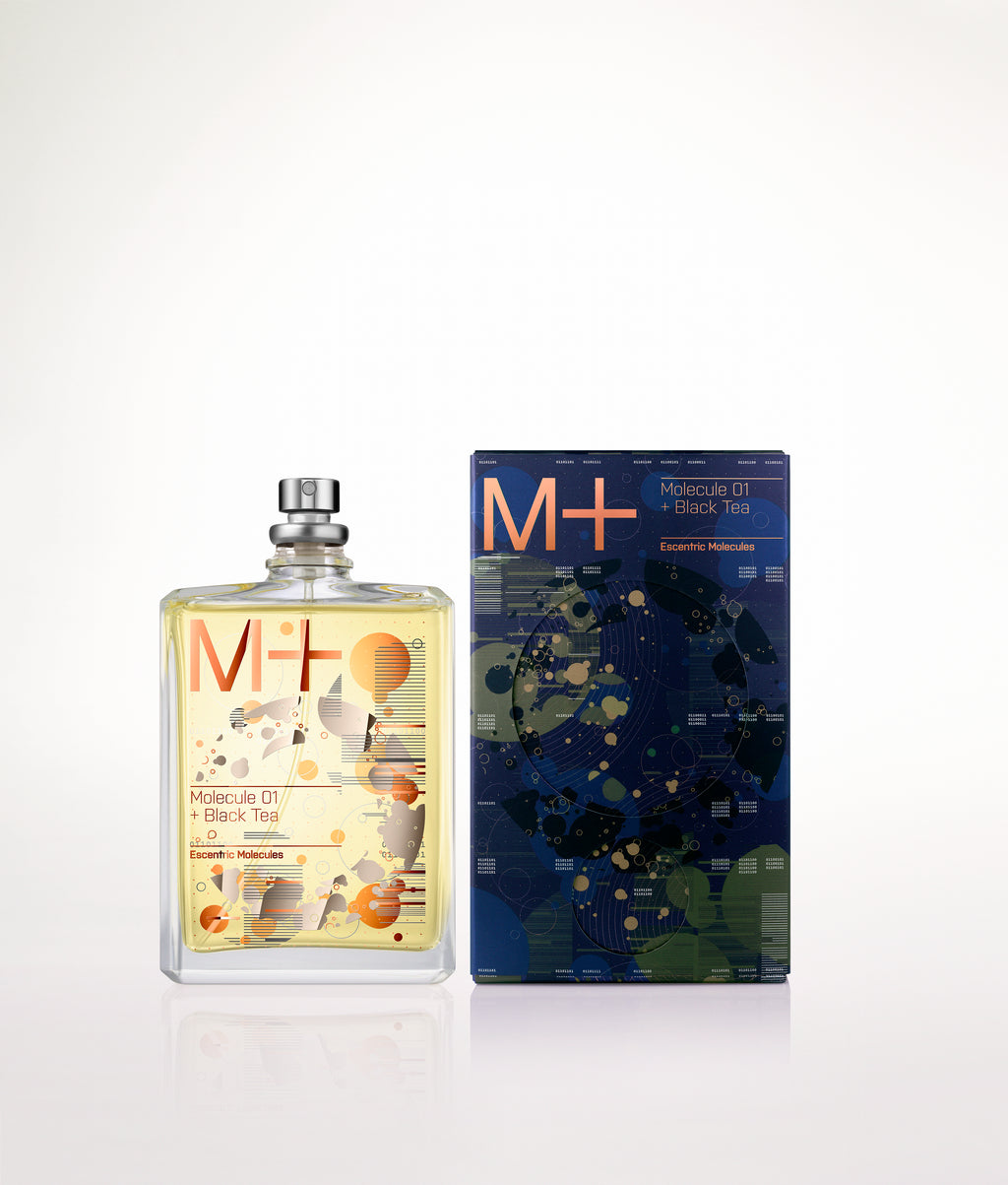 A bottle of Escentric Molecules' Molecule 01 + Black Tea fragrance is displayed beside its box, which boasts a vibrant abstract design that alludes to the luxurious essence of Iso E Super.