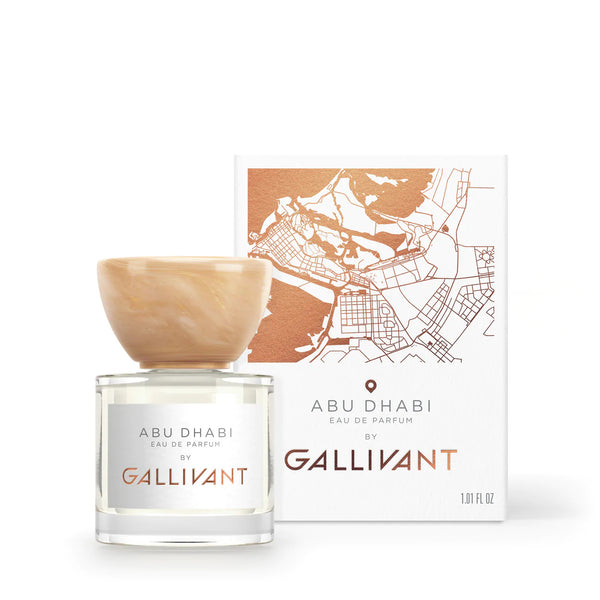 A bottle of "Abu Dhabi by Gallivant Perfumes," featuring a cream-colored cap and infused with hints of saffron, with its packaging displaying a map illustration and product title.