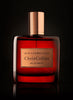 A red perfume bottle labeled "African Rooibos, Chris Collins, Eau de Parfum" with a copper cap, set against a black background, exuding the rich aroma of cedarwood and rooibos tea.