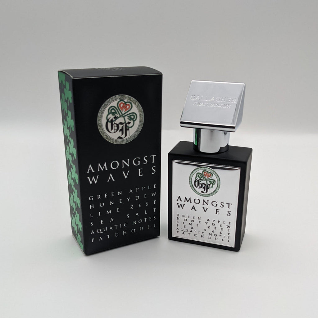 A black bottle of Gallagher Fragrances "Amongst Waves" fragrance is displayed next to its rectangular box, which highlights notes of green apple, honeydew, lime zest, sea salt, aquatic notes, and patchouli.
