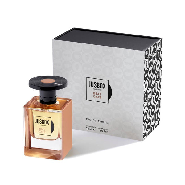 A bottle of Jusbox's Beat Café Eau de Parfum, reminiscent of the 1962 Beat Generation, is displayed next to its black and white patterned box.