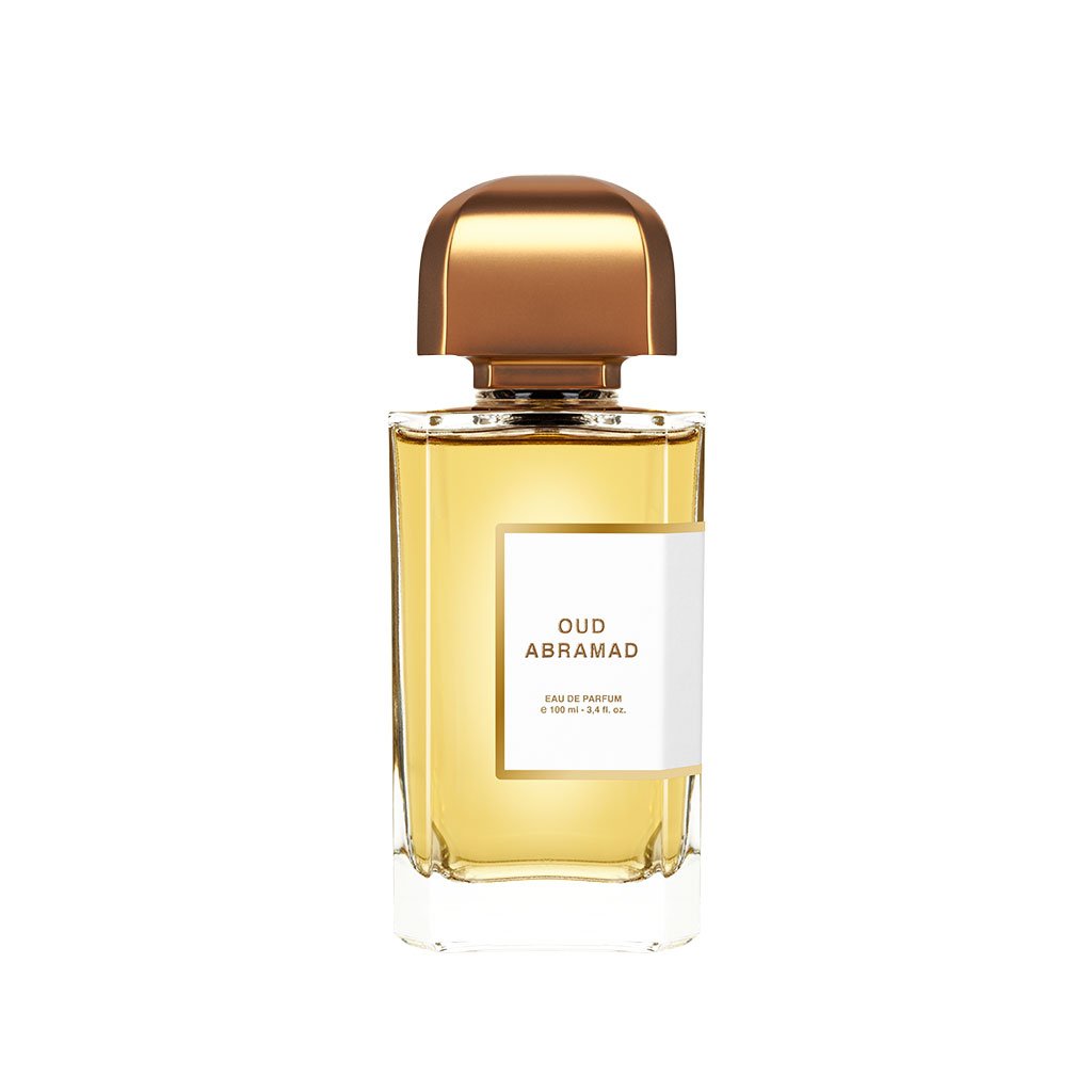 A bottle of BDK Parfums Oud Abramad Eau de Parfum with a gold cap, clear glass, and a yellowish liquid inside. Infused with the essence of agarwood and Turkish rose, the label on the bottle elegantly displays the name and details of this exquisite perfume.