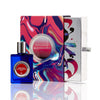 A blue perfume bottle labeled "Bloodflower" by Parfums Quartana is placed next to a vibrant, colorful box with abstract designs. The box lid is slightly open, revealing a hint of the mysterious Blood Accord within. The bottle and box are on a reflective white surface.