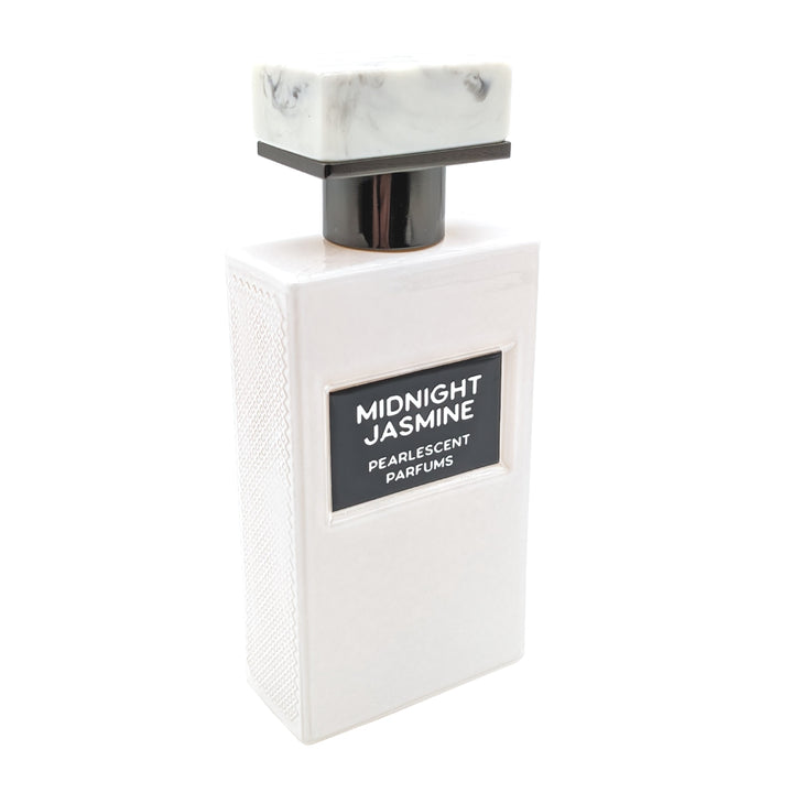 A white perfume bottle with a textured surface, labeled "Midnight Jasmine" by Pearlescent Parfums, and topped with a square, marble-patterned cap. This exquisite extrait de parfum features the enchanting essence of jasmine sambac.