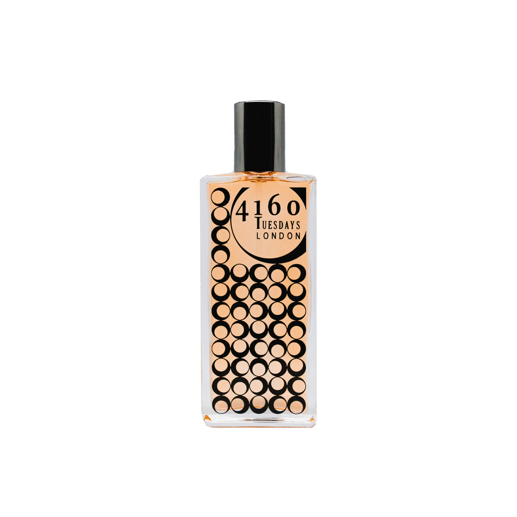 A rectangular bottle of 4160Tuesdays Brackenbury perfume with a black cap, featuring a design of numerous black circles on the front, evokes the charm of a London cottage garden in the 1920s.