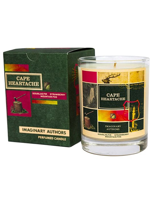 A green and red box labeled "Cape Heartache" is next to a glass candle. Both feature the same design with illustrations and text about Douglas Fir, Strawberry, and Mountain Fog from Imaginary Authors' Cape Heartache Candle, evoking the mystique of Pacific Northwest old-growth trees.