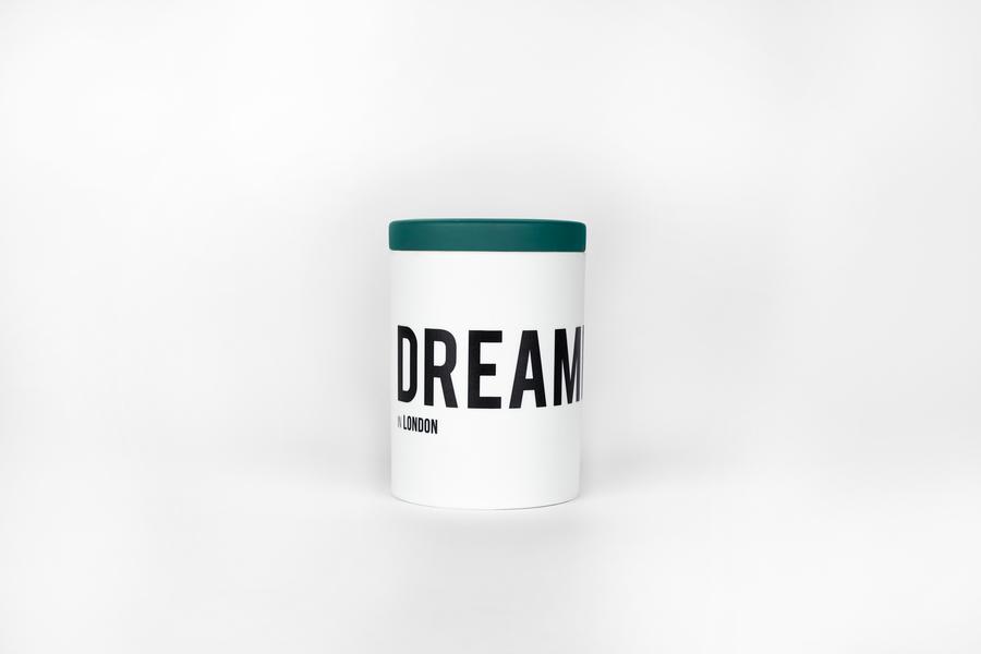 A white cylindrical container with a green lid and the product name "DREAMER in London" from Nomad Noe printed in bold black letters.