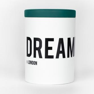 A white cylindrical container with a green lid and the product name "DREAMER in London" from Nomad Noe printed in bold black letters.