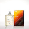 A bottle of Escentric 02 by Escentric Molecules stands next to its rectangular packaging. The bottle is clear with a minimalist design, and the box features an abstract, geometric pattern in warm colors. This fragrance exudes super-longlasting freshness, enriched with the elegance of Ambroxan and hedione.