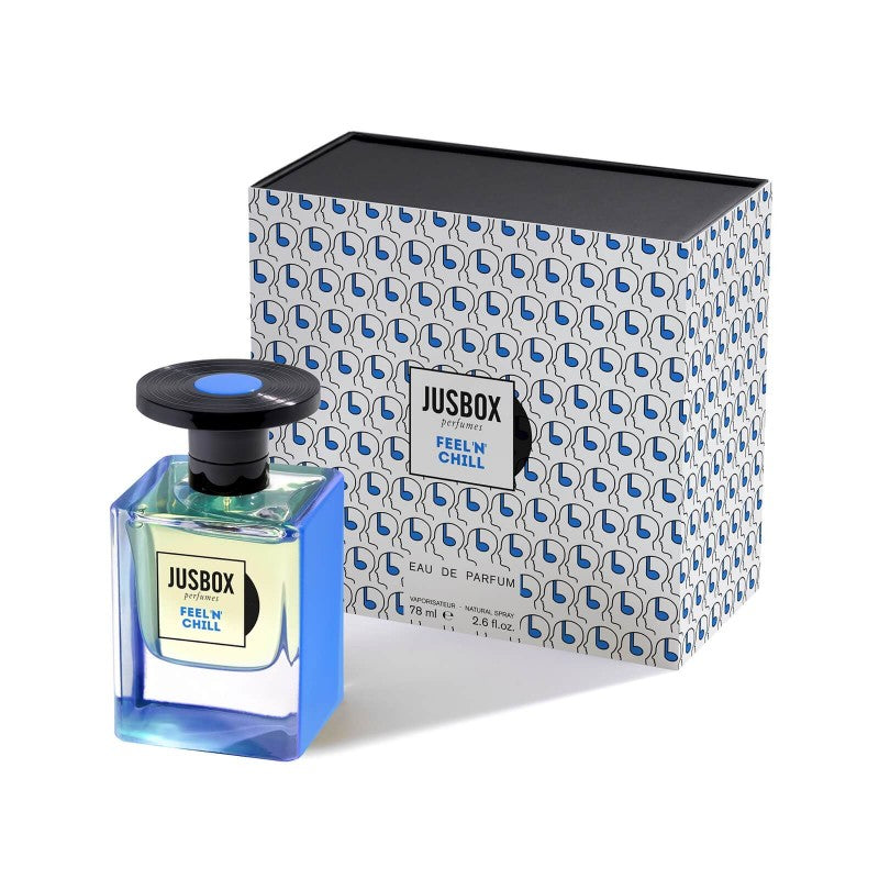 A perfume bottle labeled "Jusbox Feel 'n' Chill" is placed beside its matching blue and white patterned box, exuding an aromatherapeutic fragrance crafted by Dominique Ropion for ultimate relaxation.