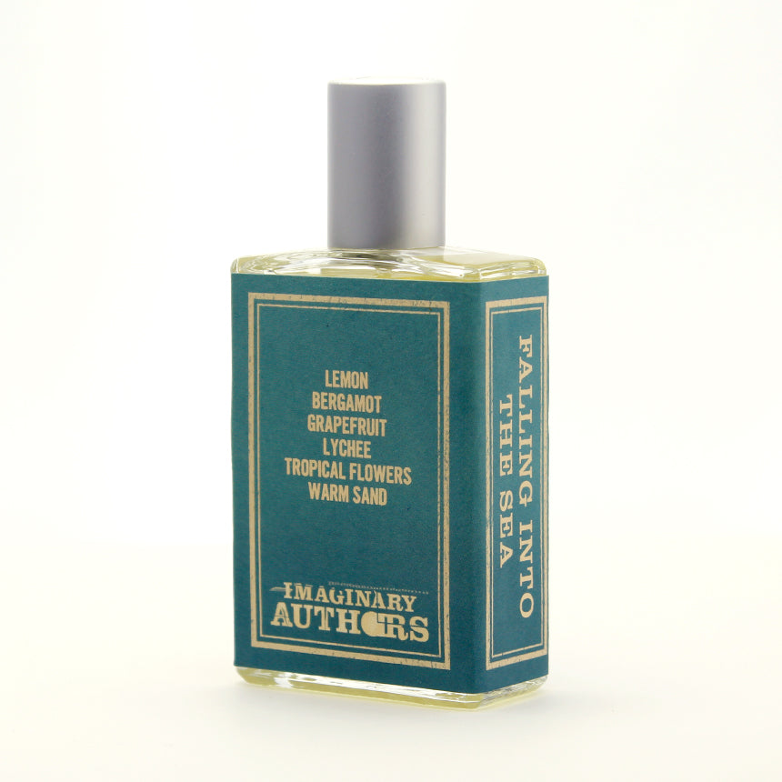 A bottle of Imaginary Authors’ Falling Into the Sea with a green label listing scents like lemon, bergamot, grapefruit, lychee, tropical flowers, and warm sand. Crafted by Josh Meyer, this summer scent features a gleaming silver cap.