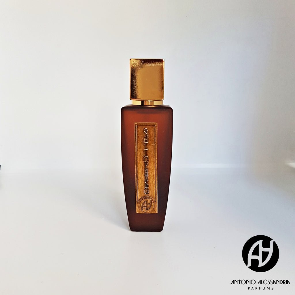 A brown perfume bottle with a gold cap and label, featuring the logo "AA" and the brand name "Antonio Alessandria" in the bottom right corner. Gattopardo is a Sicilian-inspired scent that brings a blend of gourmand and woody notes evoking Mediterranean elegance.
