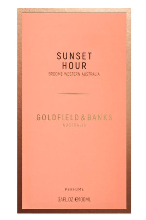 A rectangular perfume box featuring a salmon-colored front with gold borders. Text reads "Sunset Hour, desert peach essence, Broome Western Australia, Goldfield & Banks Australia, 3.4 FL OZ / 100 ML.