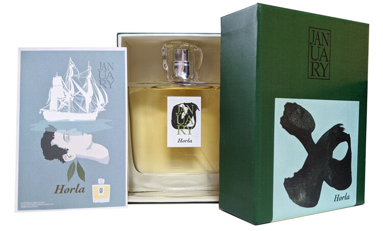 A bottle of Horla from January Scent Project, crafted by John Biebel, comes inside a box with coordinated branded packaging. The box also contains a small card adorned with an illustration of a sailing ship and a face.