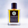 A square, transparent glass bottle with yellow liquid inside, labeled "Pearfecto" by Gallagher Fragrances, holds an olfactory paradise of scent notes including pear, melon, grapefruit, Red Champaca Absolute, patchouli, and driftwood.