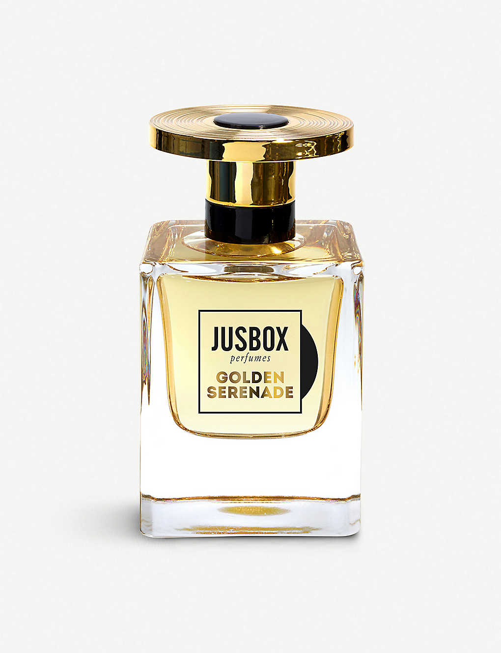 A clear bottle of Jusbox's "Golden Serenade" eau de parfum, featuring a gold-capped lid, contains a light yellow liquid infused with notes of saffron.