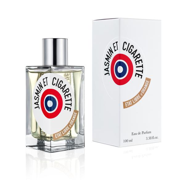 A 100ml rectangular bottle of Jasmin Et Cigarette Eau de Parfum by État Libre d'Orange, exuding a Jasmin scent that evokes vintage Hollywood glamour, stands beside its matching white box adorned with red, blue, and black branding.