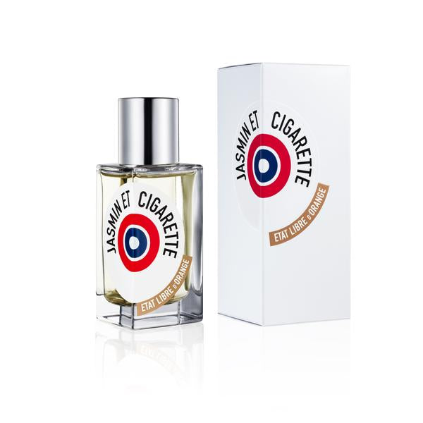 A perfume bottle labeled "Jasmin Et Cigarette" from État Libre d'Orange, evoking vintage Hollywood glamour, with the matching box displayed beside it. Both feature a design with a red, white, and blue circular logo.