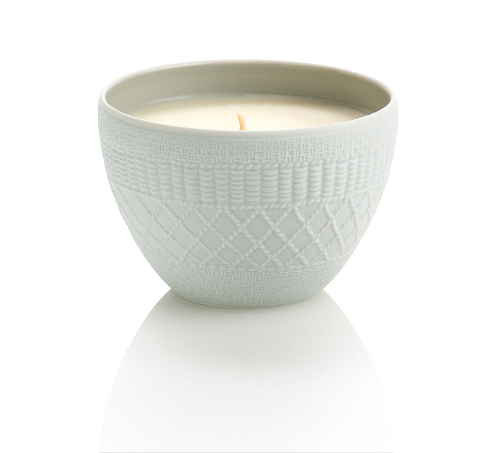 A white, textured ceramic bowl holding the Cuir de Russie single-wick candle by Le Jardin Retrouvé is centered against a plain white background, exuding the timeless elegance reminiscent of Russian Leather.