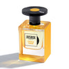 A bottle of "Live 'N' Loud" by Jusbox, featuring yellow liquid and a black cap, casts a shadow on a white background. Inspired by music, this fragrance blends notes to uplift mental well-being.