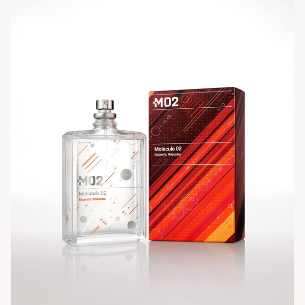 A clear bottle of Molecule 02 by Escentric Molecules with a silver cap sits next to a red and orange geometric design box on a plain white background, highlighting the pure essence of Ambroxan within.