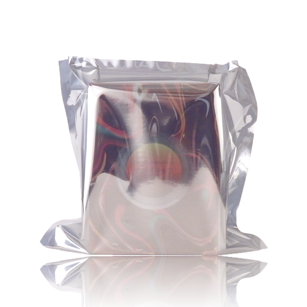 A reflective, silver, vacuum-sealed square-shaped Mandrake bag by Parfums Quartana, slightly crumpled at the edges and infused with a hint of Madagascar Vanilla, placed upright against a white background.