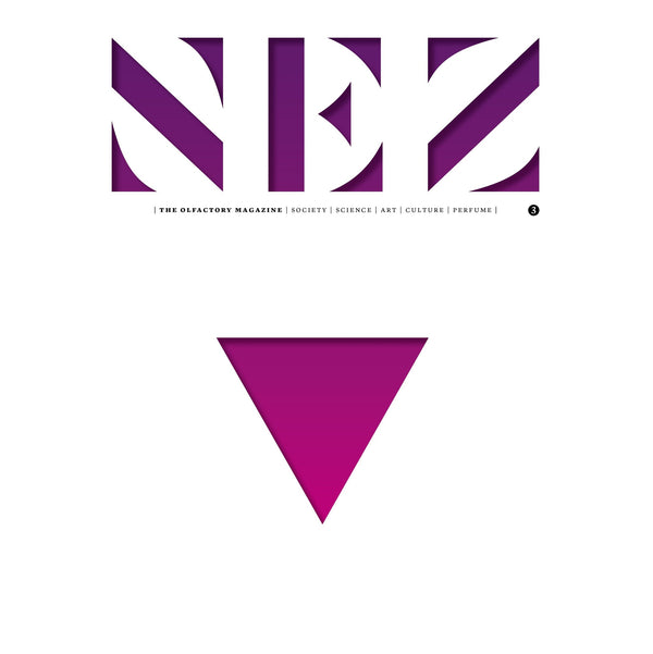 Perfume magazine issue cover close-up with purple geometric logo and centered magenta triangle