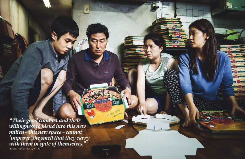 Four people sit in a dimly lit room, surrounded by the magazine Nez 08 Autumn 2019 and the addictive fragrance of Addictive Substances. A quote is overlaid on the image, discussing the group's integration into a new environment.