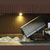 Narcissus perfume booklet photo: truck unloading pale material near a storage building