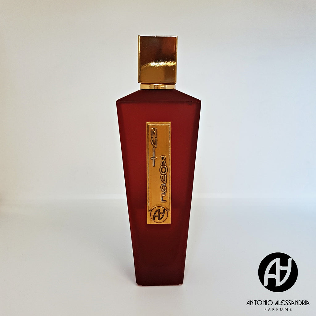 A red bottle of Nuit Rouge by Antonio Alessandria, featuring a gold cap and label, displayed on a white background. The brand's logo is visible at the bottom right corner. This exquisite fragrance boasts spicy top notes and a rich, leathery scent that captivates the senses.