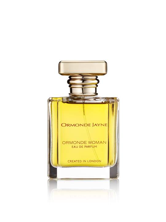 A bottle of Ormonde Jayne Ormonde Woman featuring a square, gold-capped design and containing a yellow liquid. Created in London, this seductive perfume weaves the intoxicating notes of Black Hemlock with the allure of jasmine absolute for a captivating fragrance experience.