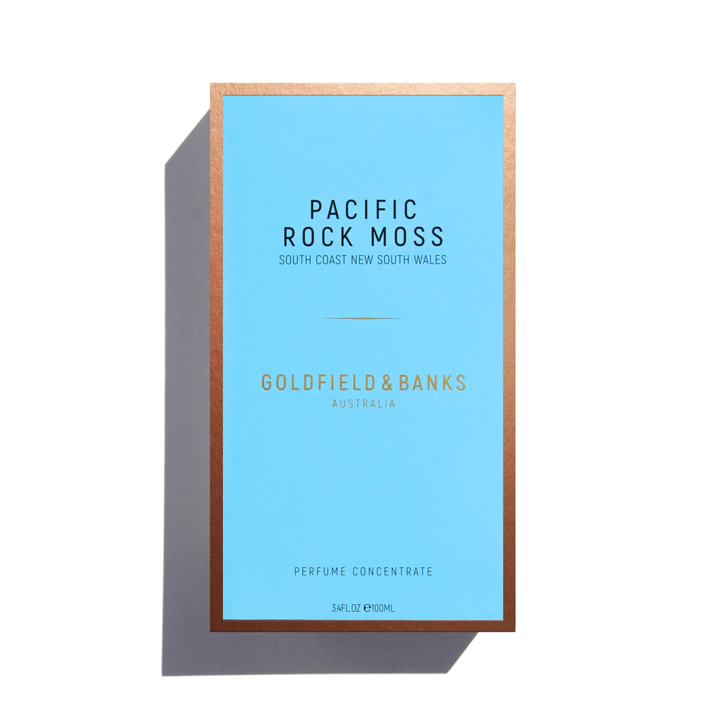 A rectangular bottle of **Goldfield & Banks** perfume concentrate named **"Pacific Rock Moss"** from South Coast New South Wales, featuring a blue label with brown borders. This fresh perfume encapsulates the essence of beach life, making it the perfect summer fragrance.