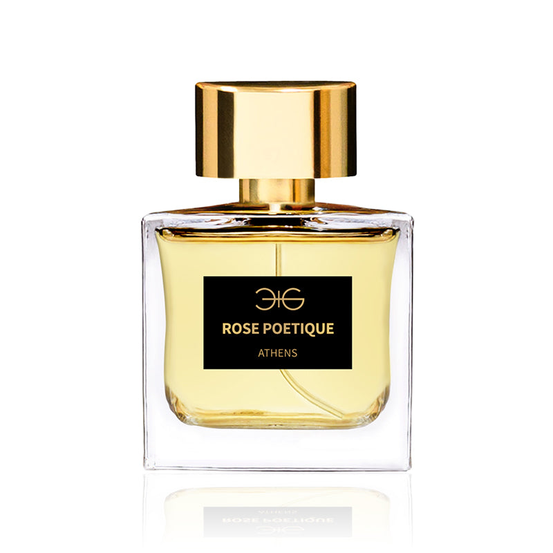 A clear glass bottle of perfume labeled "Rose Poetique Manos Gerakinis" with a gold cap and amber-colored liquid inside, offering an enchanting floral oriental scent.