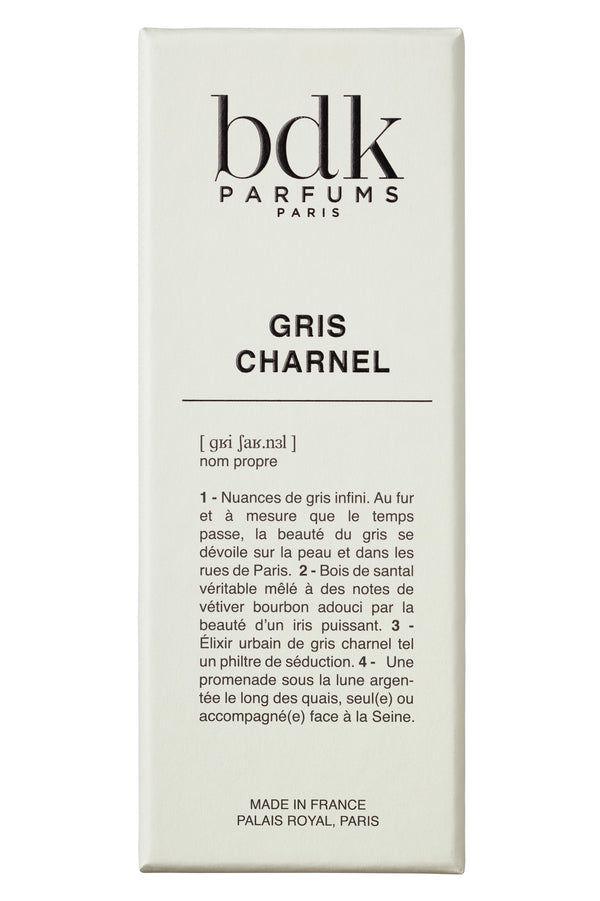 A white packaging box with the brand name "BDK Parfums" and the fragrance name "Gris Charnel" printed on it, enhanced by descriptive text in French. It evokes serene strolls through Jardin des Plantes and hints of sandalwood from India.