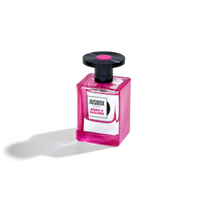 Jusbox's Siren & Sailors perfume captures the essence of Camden Town and comes in a pink and clear rectangular glass bottle with a black circular cap.