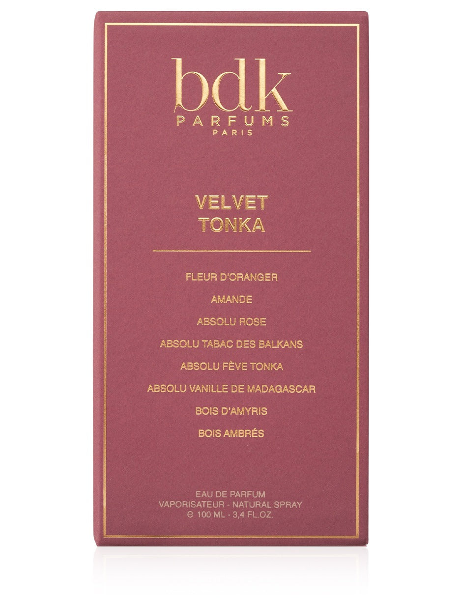 A burgundy box of BDK Parfums' Velvet Tonka Eau de Parfum, featuring elegant gold text detailing fragrance notes such as tonka bean, orange blossom, almond, fleur d'oranger, and absolu rose.