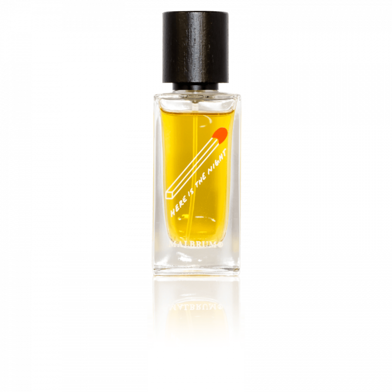 Wildfire by Malbrum Parfums is a clear glass bottle with a black cap, filled with yellow liquid. The label reads "Here is the Night" and features a minimalist design of a red dot emitting a white streak, perfectly capturing the essence of male seductiveness.
