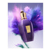 A purple perfume bottle with a gold cap and label, surrounded by vibrant purple and green powder bursts, floating against a light background. The label reads "Accento" and "Xerjoff." This exquisite piece of pure luxury, Accento Xerjoff, is imbued with a delightful fruity scent.