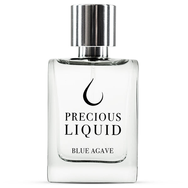 A clear glass perfume bottle with a silver cap. The label reads "Precious Liquid Blue Agave," hinting at the delicate blend of blue agave and woody fragrance.