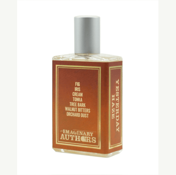 A bottle of Yesterday Haze perfume by Imaginary Authors. The label lists notes: fig, iris, cream, tonka, tree bark, walnut bitters, orchard dust. This seductive scent comes in a rectangular bottle with a metallic cap.
