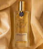 A rectangular glass bottle labeled "Baïkal Leather" by Nicolaï is placed on a light beige, soft-textured fabric. The bottle, encapsulating spicy citrus and woody notes, has a golden cap and a small black emblem at the neck.