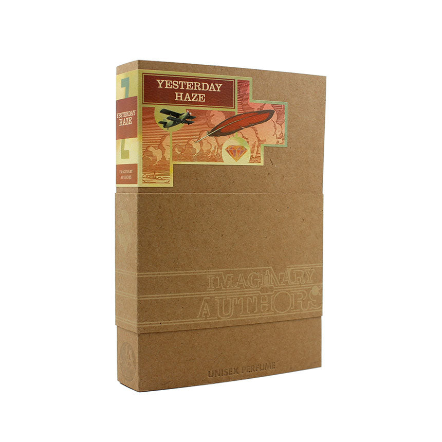 A cardboard box of Imaginary Authors' "Yesterday Haze," featuring colorful vintage-style artwork of an aircraft and hot air balloon on the label. Created by Lenora Blumberg, this seductive scent captures the essence of nostalgia and adventure.