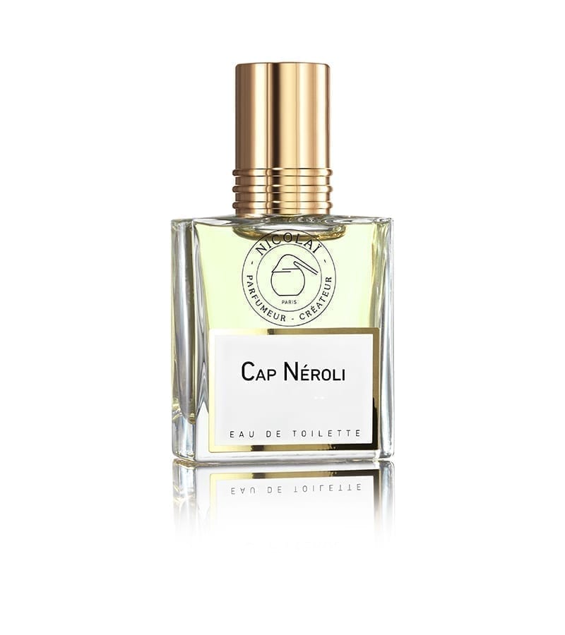 A bottle of Cap Neroli by Nicolaï, featuring a clear rectangular glass design with a gold cap and white label, exudes the bright essence of neroli and subtle hints of bitter-orange.