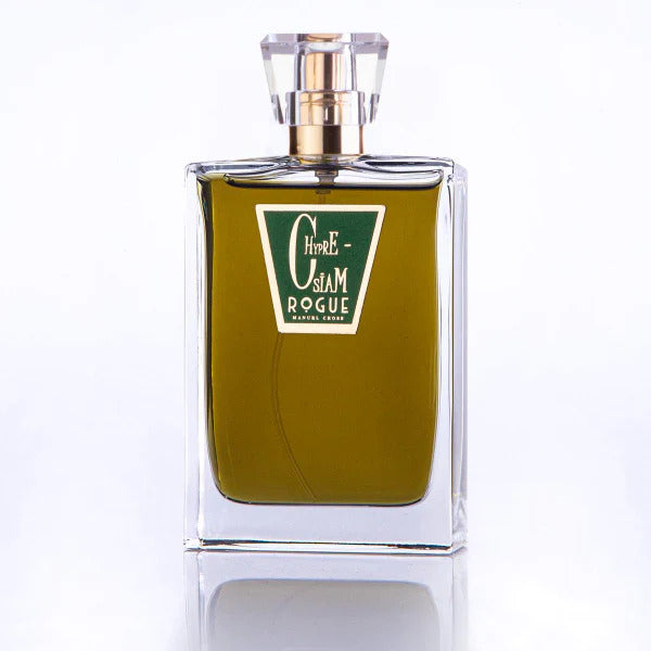 A clear glass bottle of perfume with a gold cap and a green label displaying the text "Chypre-Siam Rogue Perfumery." The bottle contains an amber-colored liquid, capturing the essence of oakmoss and embodying a classic chypre fragrance.